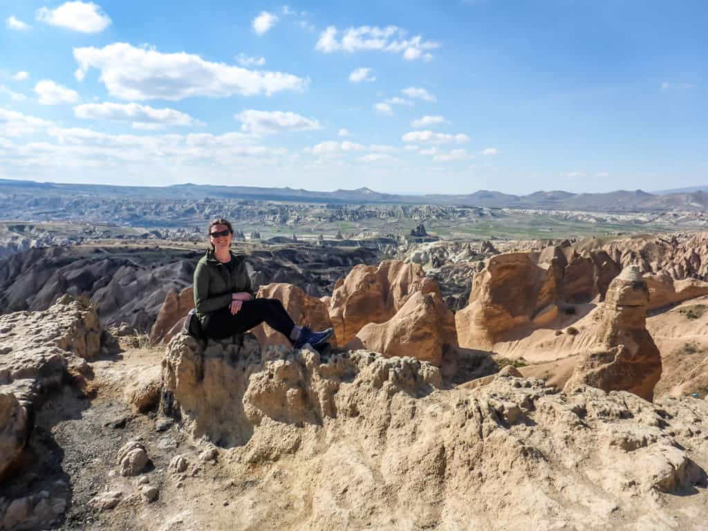 40+ Countries with Working Holiday Visas in 2024 6 Nina sitting on a rock in Turkey in front of the fairy chimney in Cappadoccia when she visited there.