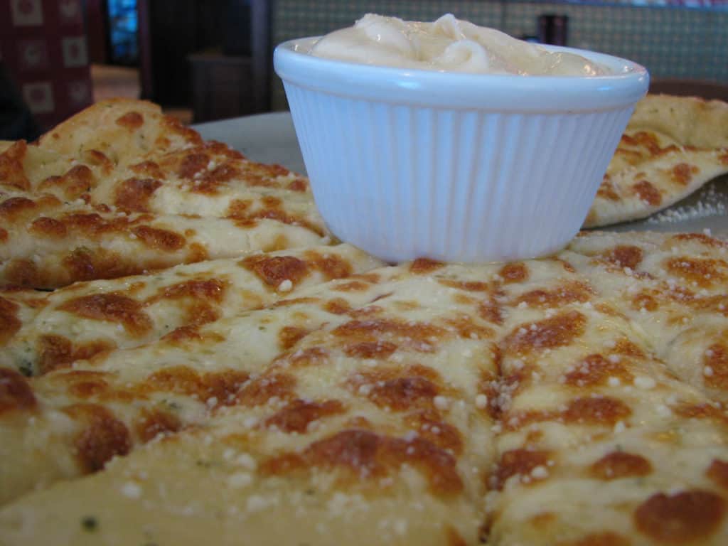 Canada Cuisine to Try: Traditional Food Canada is Famous For 8 Up close shot of delicious Canadian garlic fingers with donair sauce