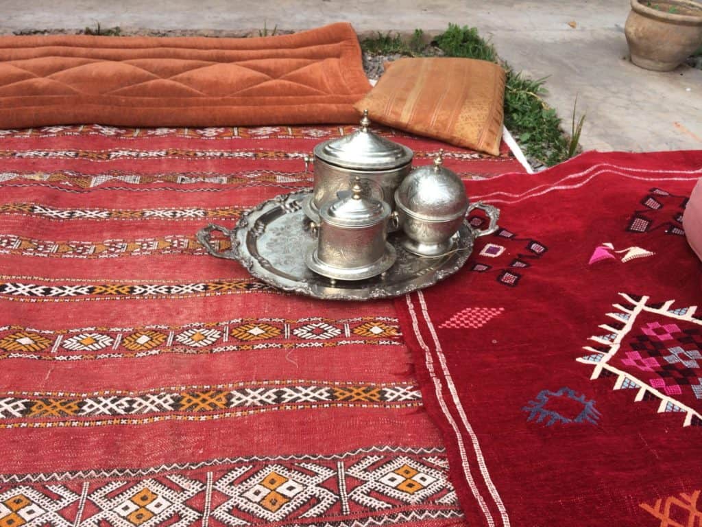 11 Best Cooking Classes in Marrakech in 2024 11 Moroccan tea on a rug at an Amal non-profit event.