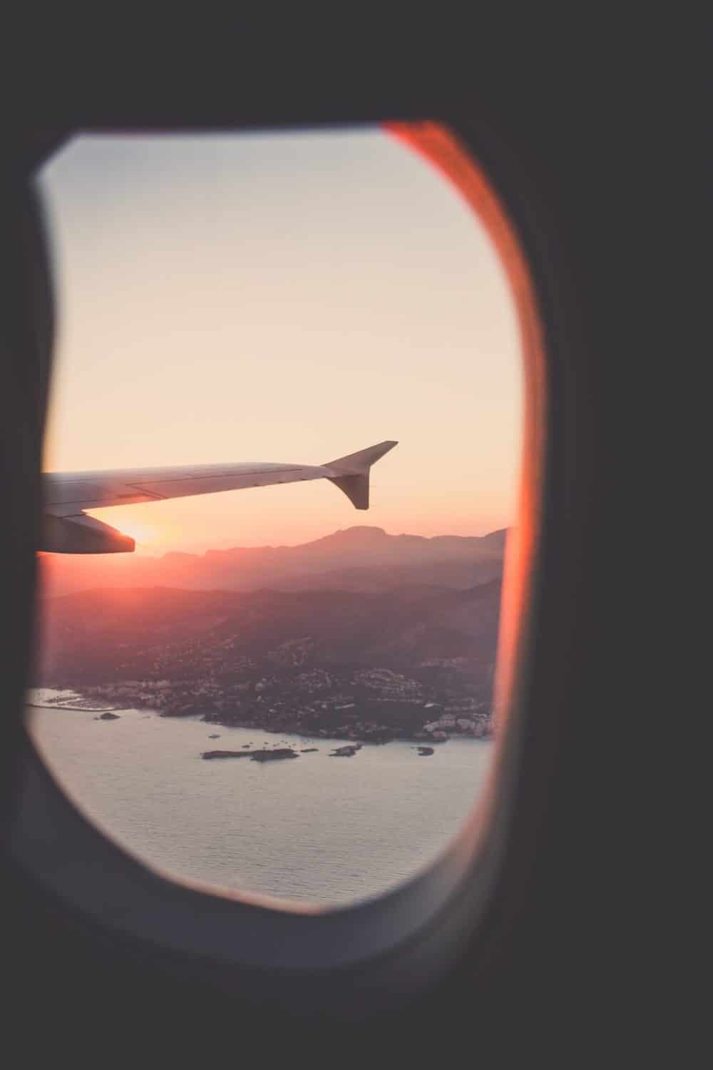 How I Travel Plan: Travel Planning Tips 6 View out of a plane window onto the wig at sunset as they head off for vacation