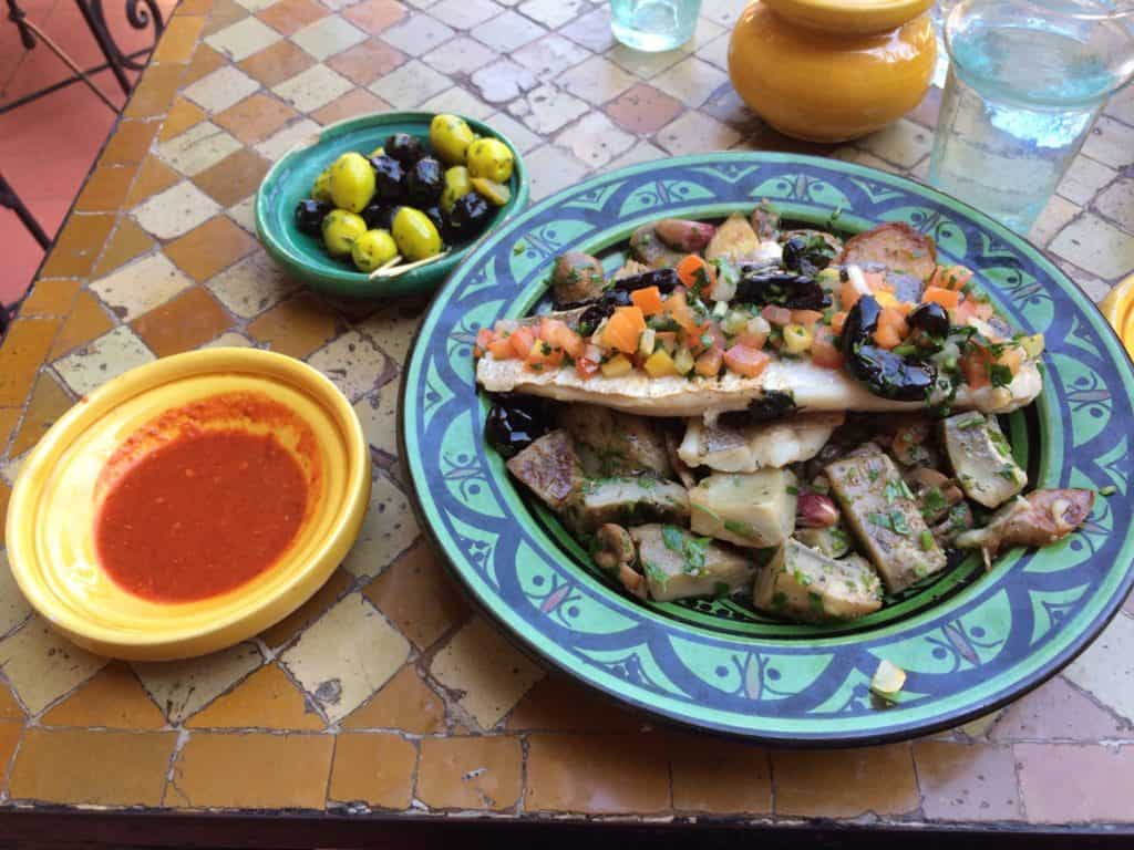 The Unbelievable Location That Made a Travel Pro Say 'Never Again!' 3 Cooked fish with roasted vegetables at dinner in Casablanca on a brightly coloured plate. This was not the meal that got me sick
