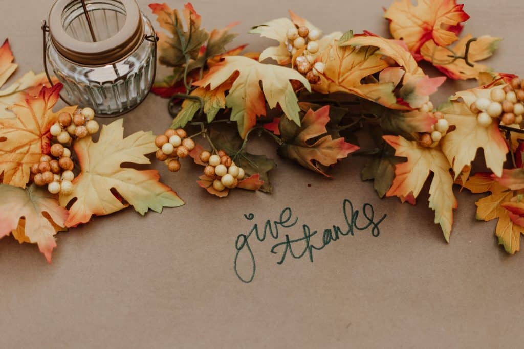 Canadian vs American Thanksgiving: What's the Difference? 7 "Give thanks" written on a construction paper tablecloth for a thanksgiving dinner.