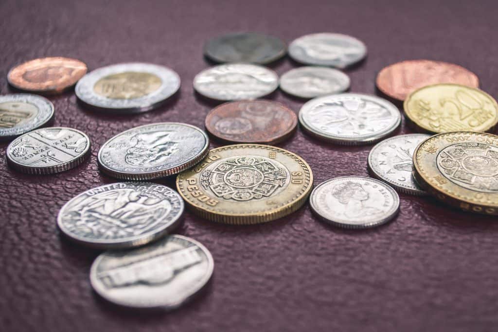 45 Pros and Cons of Living in Canada from a Canadian 4 Coins on a leather backdrop, including Canadian coins