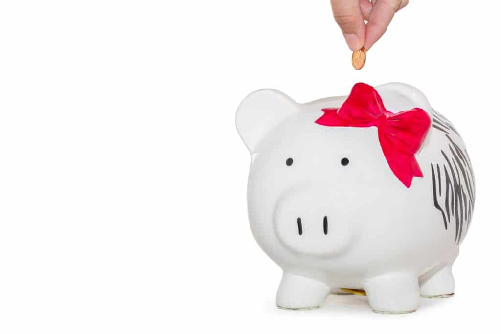 57 New Zealand Travel Tips (2024 Local's Guide) 10 White piggy bank with a pink bow as someone puts money in the top