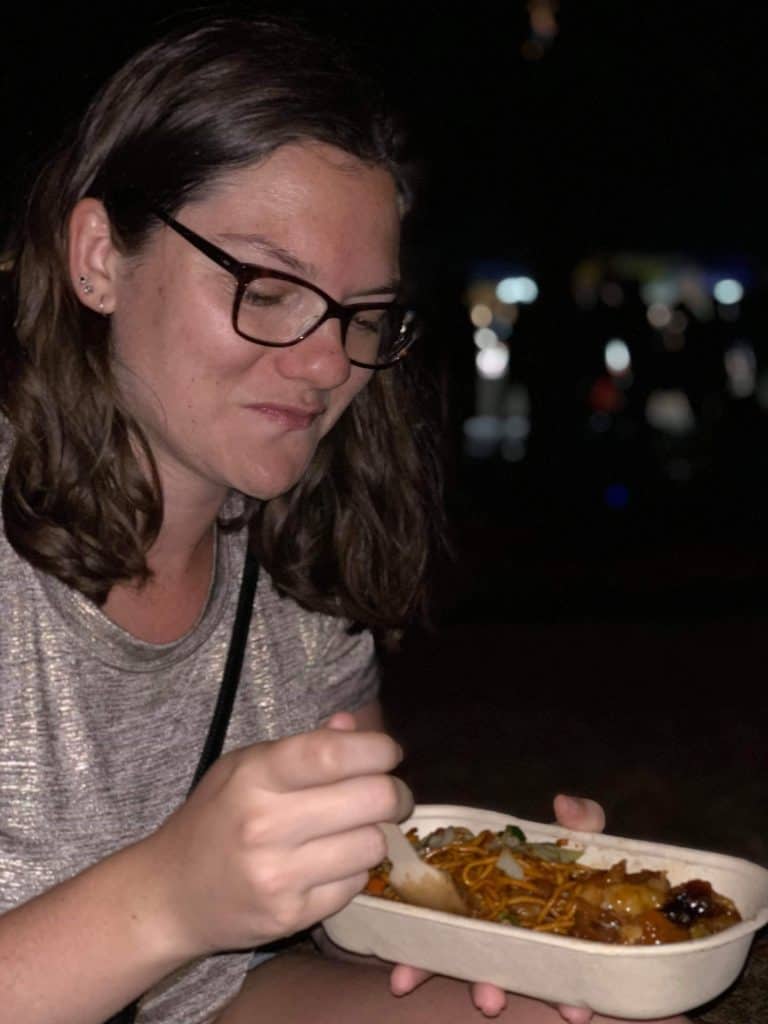 19 Pros and Cons of Living in Auckland NZ 2 Nina smiling and eating street food while living in New Zealand