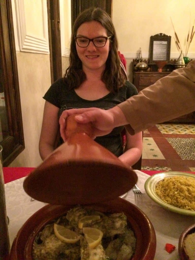 Riad Le Clos Des Arts: Honest Hotel Review 5 Nina grinning with anticipation as a waiter uncovers a tagine during dinner ar Riad Le Clos Des Arts in Marrakech