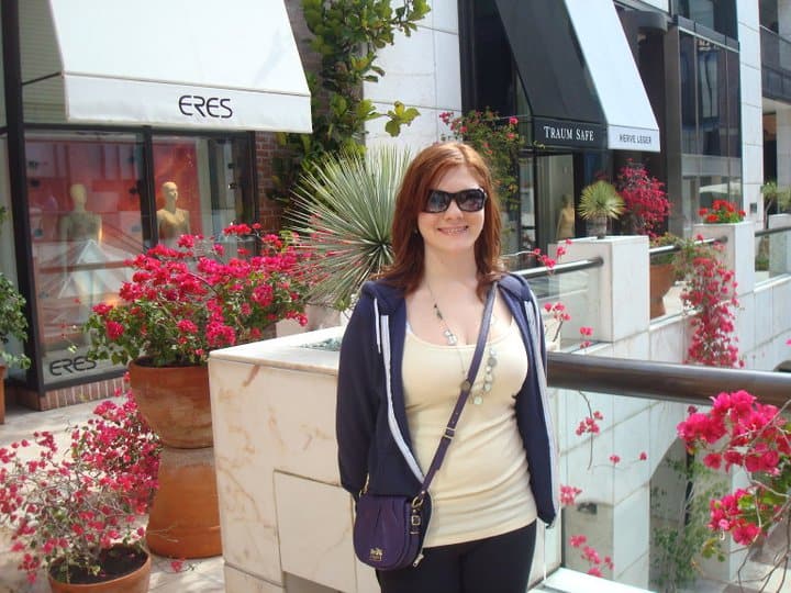 It's Hard to Pack When You Hate Your Body 3 Nina posing on Los Angeles in a mall. Her hair is dyed ginger and she has a tight lipped smile on her face.