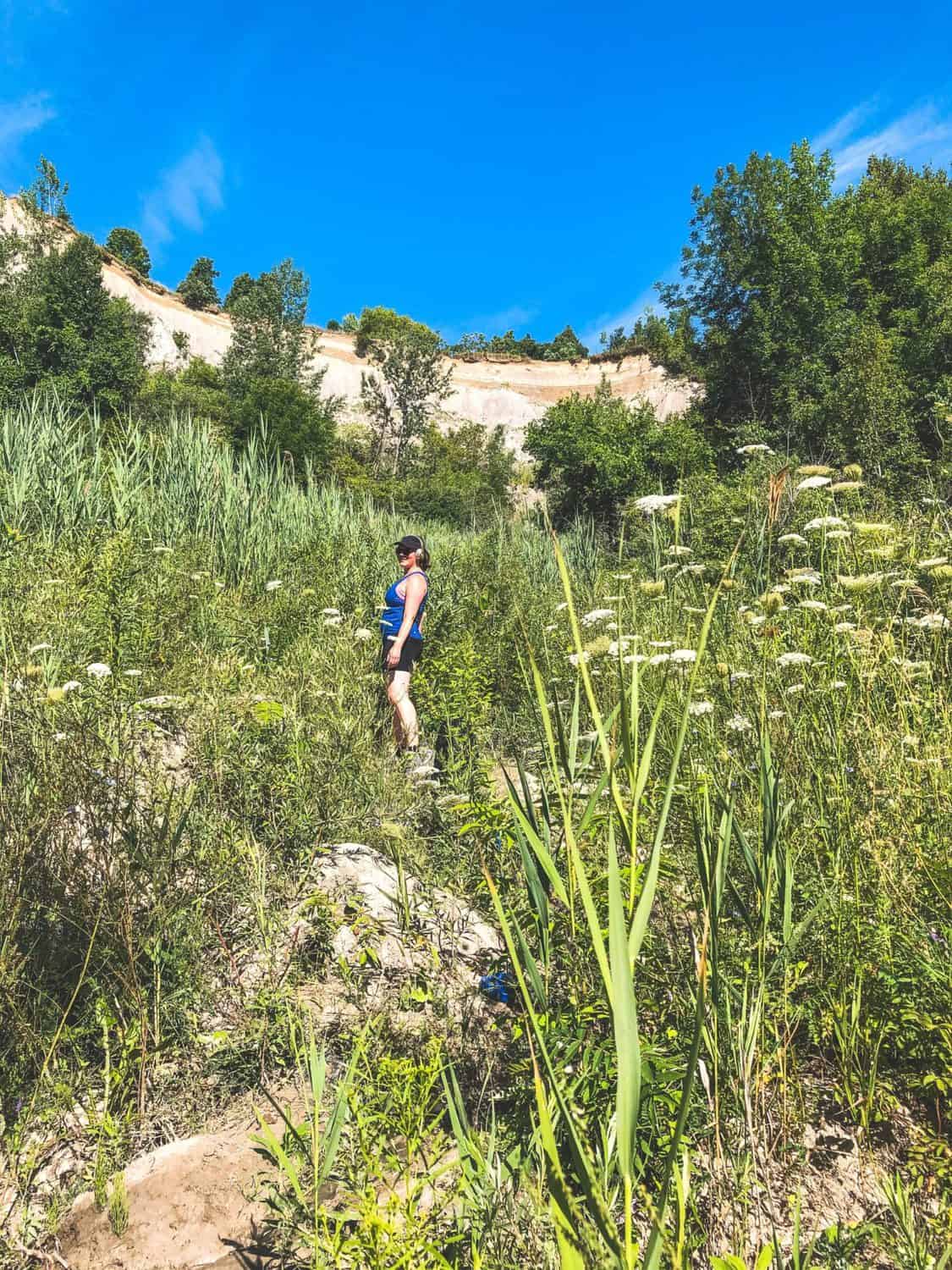 Scarborough Bluffs Trail: Hiking to the Best Lookout 13 Scarborough Bluffs hiking trail with Nina posing in the brush beneath the Cathedral Bluffs
