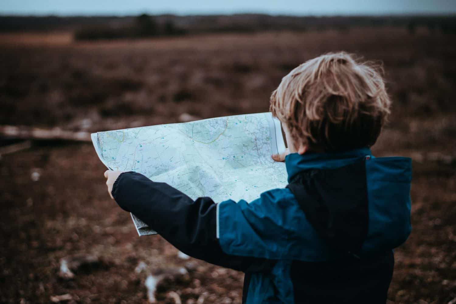 15 Unique Solo Staycation Ideas for Singles 15 Young boy looking at a map on a vacation