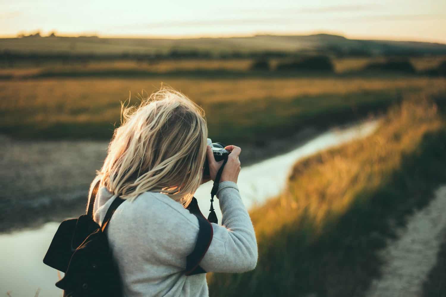 15 Unique Solo Staycation Ideas for Singles 5 Girl taking a photo of field at the golden hour for a staycation photography tour