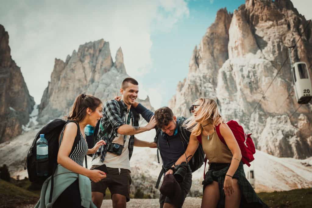 85 Best Solo Travel Quotes and Captions for Instagram 2024 4 Friends laughing at a funny instagram caption for solo travel as they explore