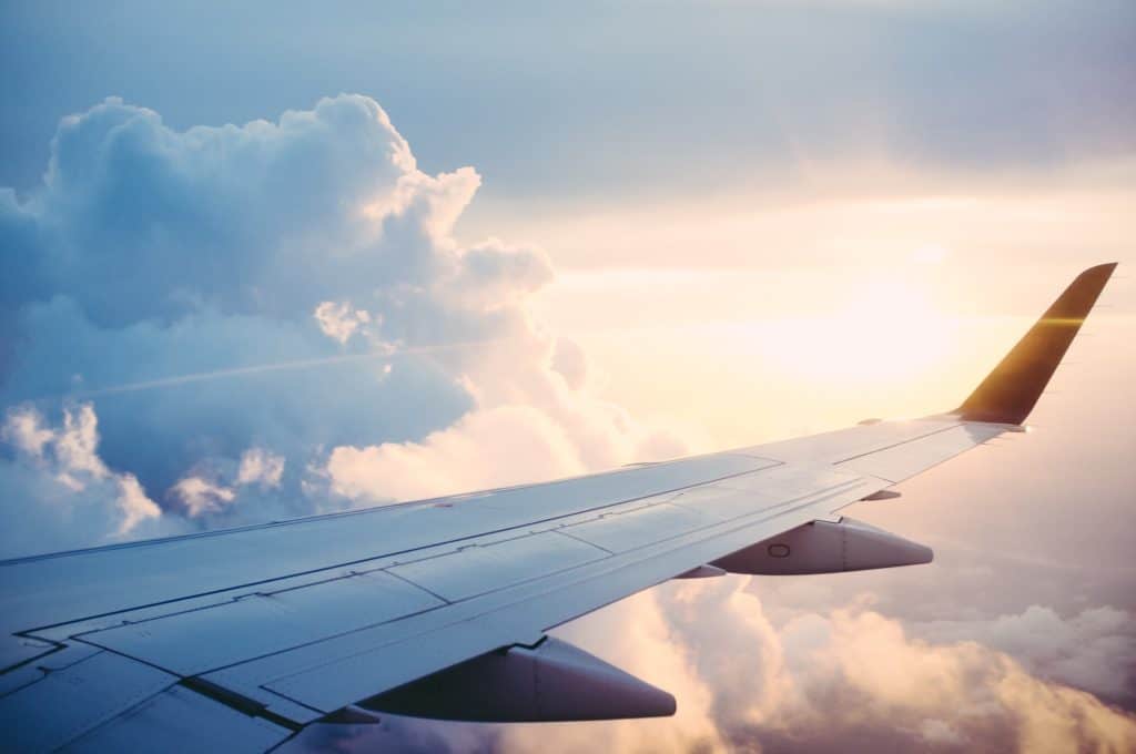 29 Greatest Ways to Make Money Travelling the World 10 Plane wing flying through clouds during white light