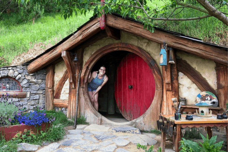 135 New Zealand Slang: From Sweet As to Swear Words 14 Nina looking out of a red hobbit hole door in New Zealand