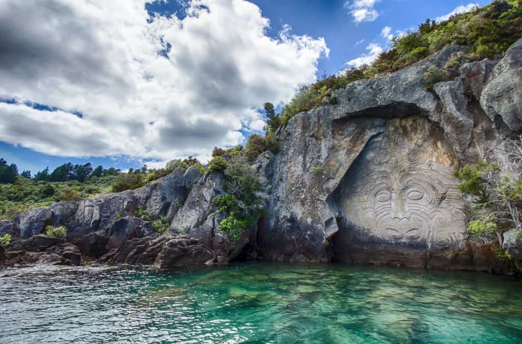 25 Pros and Cons of Living in New Zealand 3 Maori carvings in a rock wall in Taupo, New Zealand