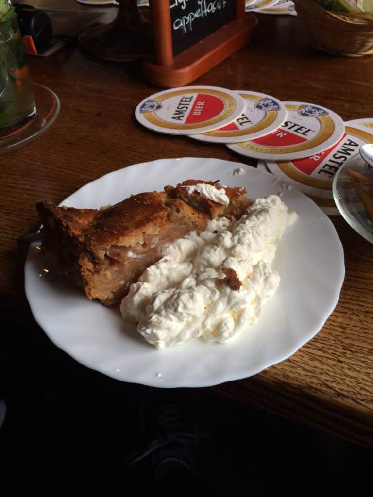 What You Need to Know Before Travelling to Amsterdam Alone 8 Dutch apple pie on a plate with thick whipped cream
