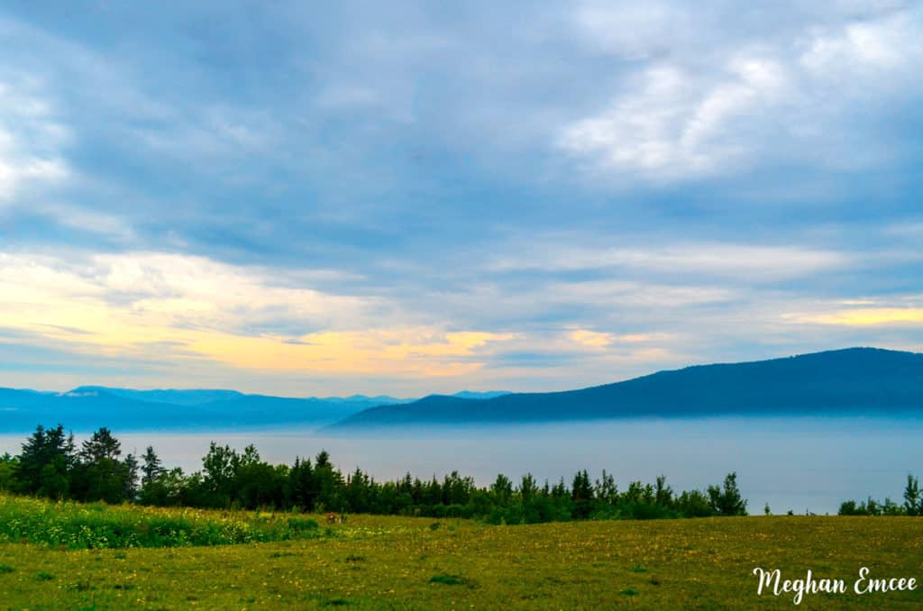 Best Quebec Road Trip (An Epic 2 Week Itinerary) 8 Sunrise views over the lake in Charlevoix with mountains in the background. Quebec road trip stop
