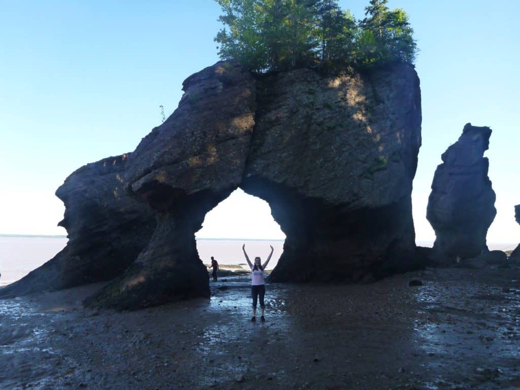 Visit the Highest Tides in the World at Hopewell Rocks, NB 5 Nina posing in front of lover's rock at hopewell rocks at low tide