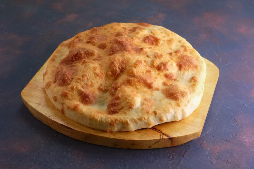 Canada Cuisine to Try: Traditional Food Canada is Famous For 17 Bannock bread on a wooden cutting board