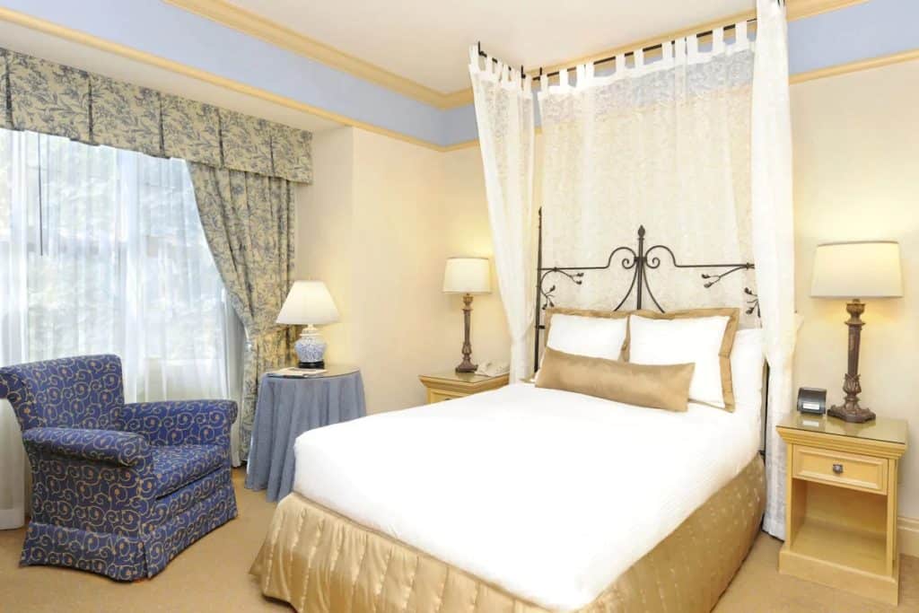 15 Best Hotels in Toronto with Private Hot Tubs (2024) 23 King bed with old fashioned adornments in a modern room