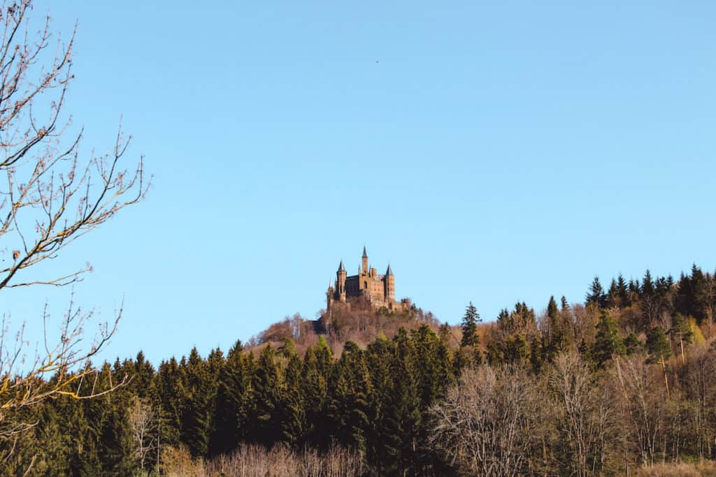 11 Fairytale Castles in Germany: Most Beautiful Castles to Tour 8 Distant view of Hohenzollern castle amongst the forest of Bavaria in Germany