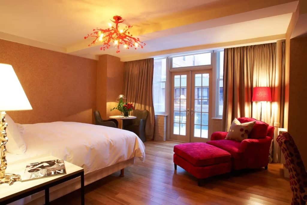 15 Best Hotels in Toronto with Private Hot Tubs (2024) 19 Romantic bedroom with a king bed and a pink sofa