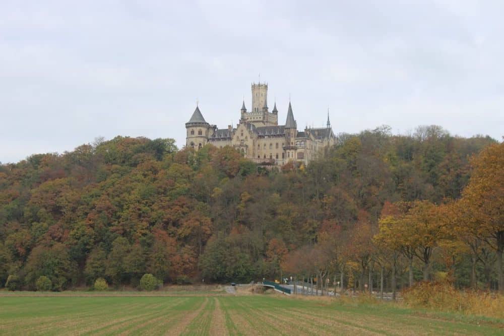 11 Fairytale Castles in Germany: Most Beautiful Castles to Tour 5 Mariensburg nestled amongst colourful fall leaves, showing that it's one of the most beautiful castles in Germany