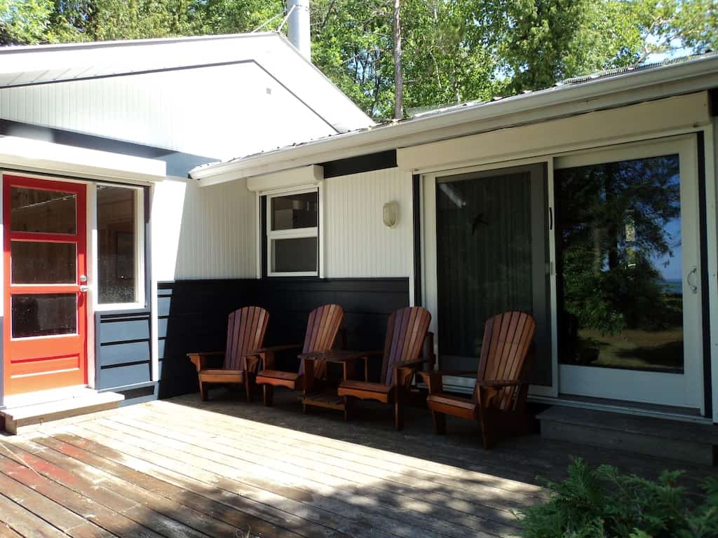 20 Cozy Cabins in Ontario for an Autumn Weekend Getaway 2 Deck of a cozy cabin in Ontario with four muskoka chairs