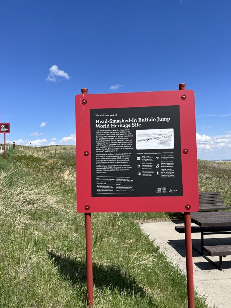 83 Bucket List Canada Things to Do in 2025 from a Canadian 36 Information sign at the Head-Smashed-In Buffalo Jump World Heritage Site in Alberta, Canada, offering historical insights into indigenous hunting practices and cultural heritage.