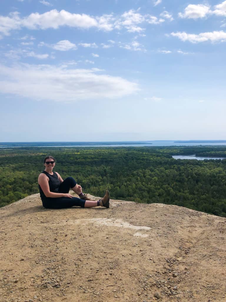 Hiking the Cup and Saucer Trail on Manitoulin Island 17 Nina in hiking gear sitting on the Cup and Saucer lookout