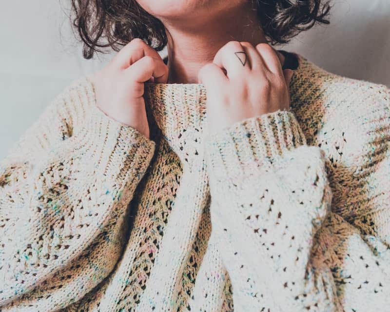 160 Best Fall Quotes and Captions for Instagram 2024 8 Woman cuddled up in a knit white sweater