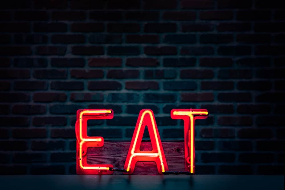 Eating Alone While Traveling: Overcoming Fear of Eating Alone 2 Neon red "EAT" sign