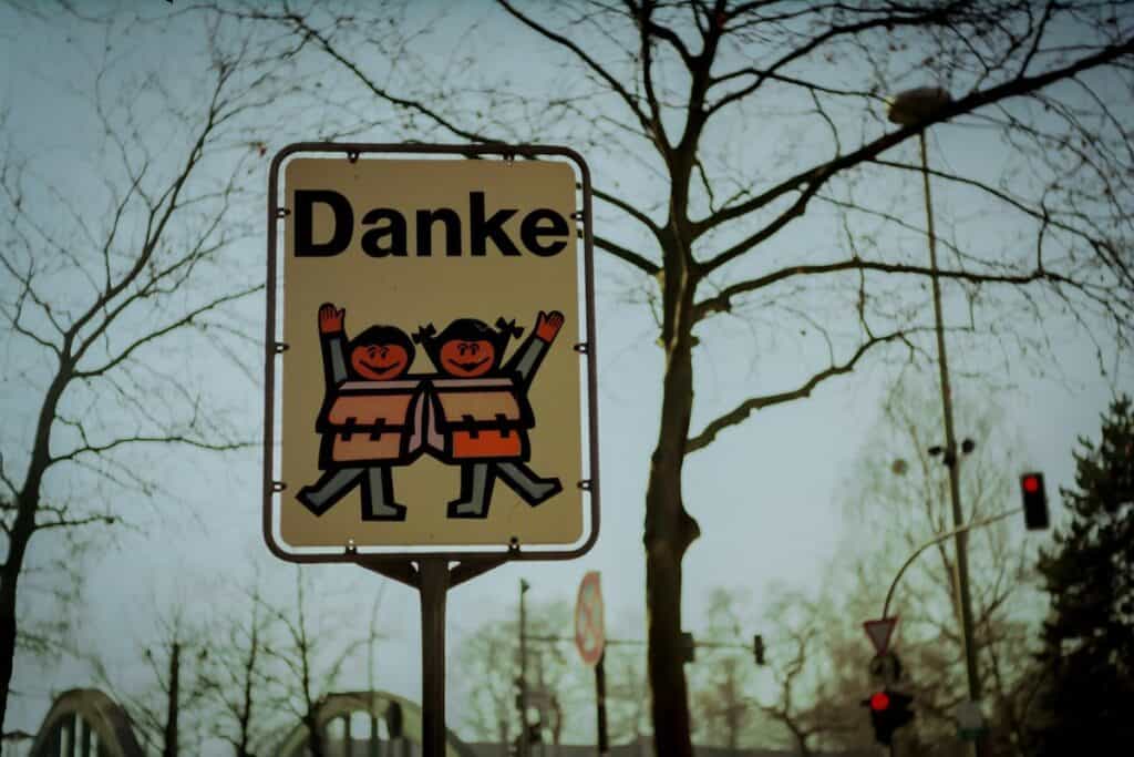 How to Say Thank You in 100 Different Languages 3 Danke - how to say thank you in German - on a street sign with two dancing cartoon children on the sign.