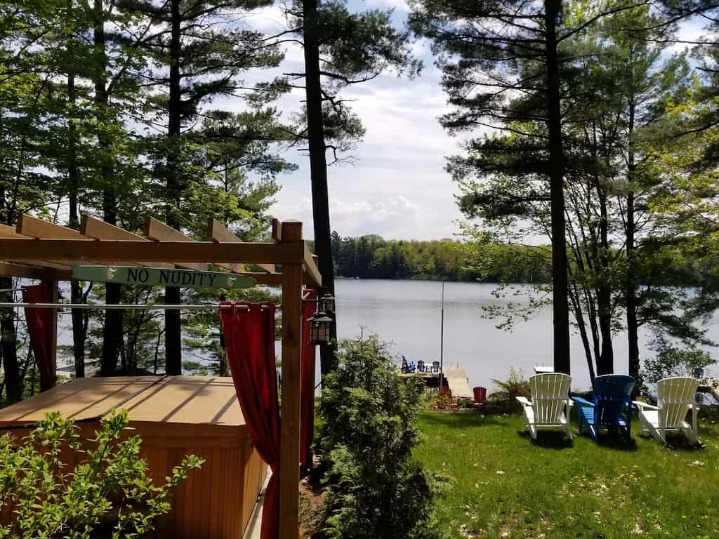 20 Top Airbnb Cottages in Muskoka for an Epic Getaway 57 Cottage hot tub and Muskoka chairs overlooking the lake.
