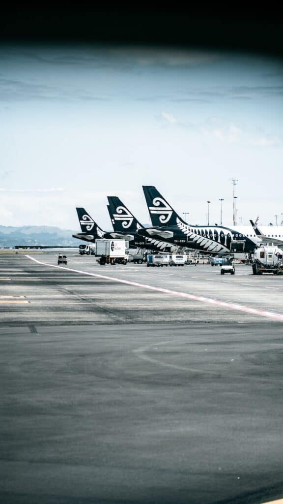 19 Pros and Cons of Living in Auckland NZ 5 Air New Zealand planes at the Auckland airport. White planes with black tails and the silver fern painted in white.