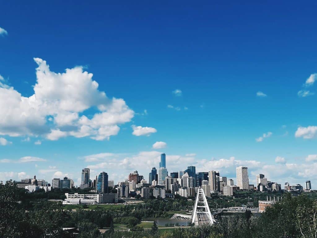 15 Best Cities to Live in Canada in 2024 (Local Tips!) 6 Edmonton city skyline with the tall office buildings and the iconic white bridge over the river. Edmonton is a great city to live in Canada for new immigrants and families.