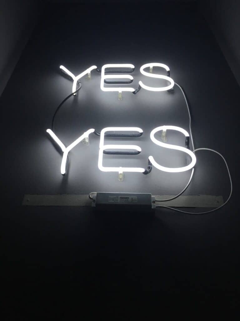 How to Say Yes and No in 100 Different Languages 3 Two neon lights that say "yes" on a wall in white