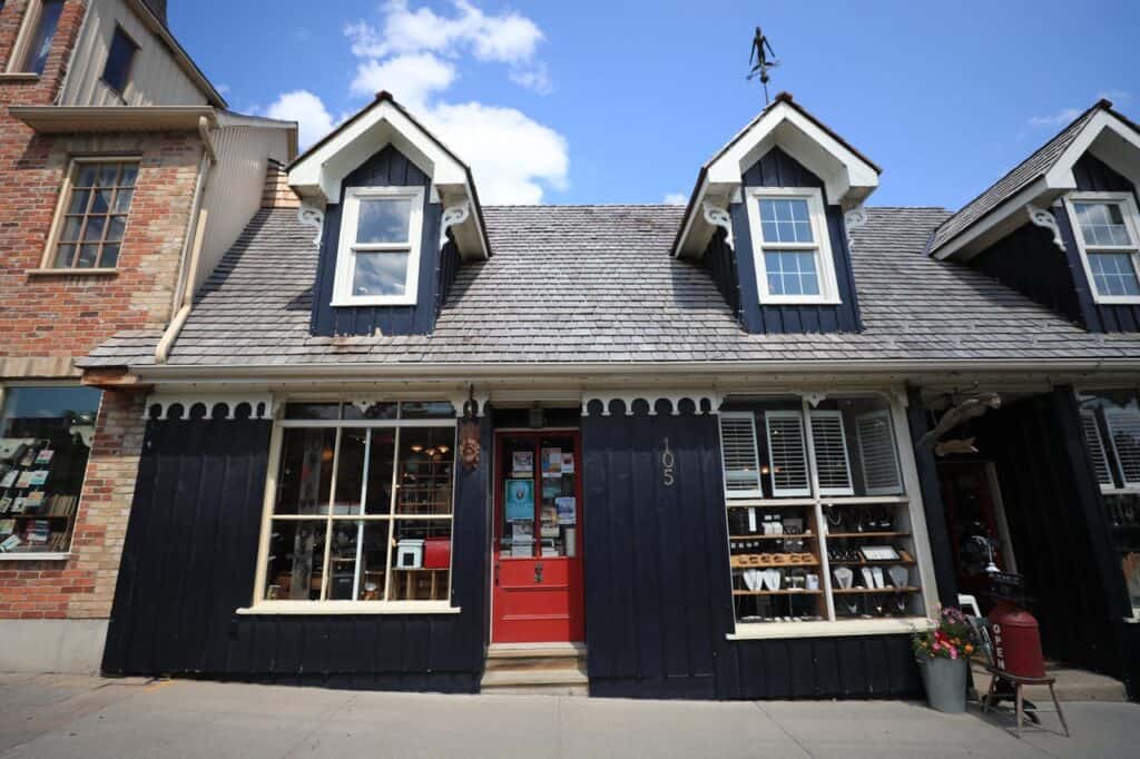 25 Things to Do in Elora, Ontario 8 Elora shops. A black building with windows looking into the jewellery and antiques to buy.