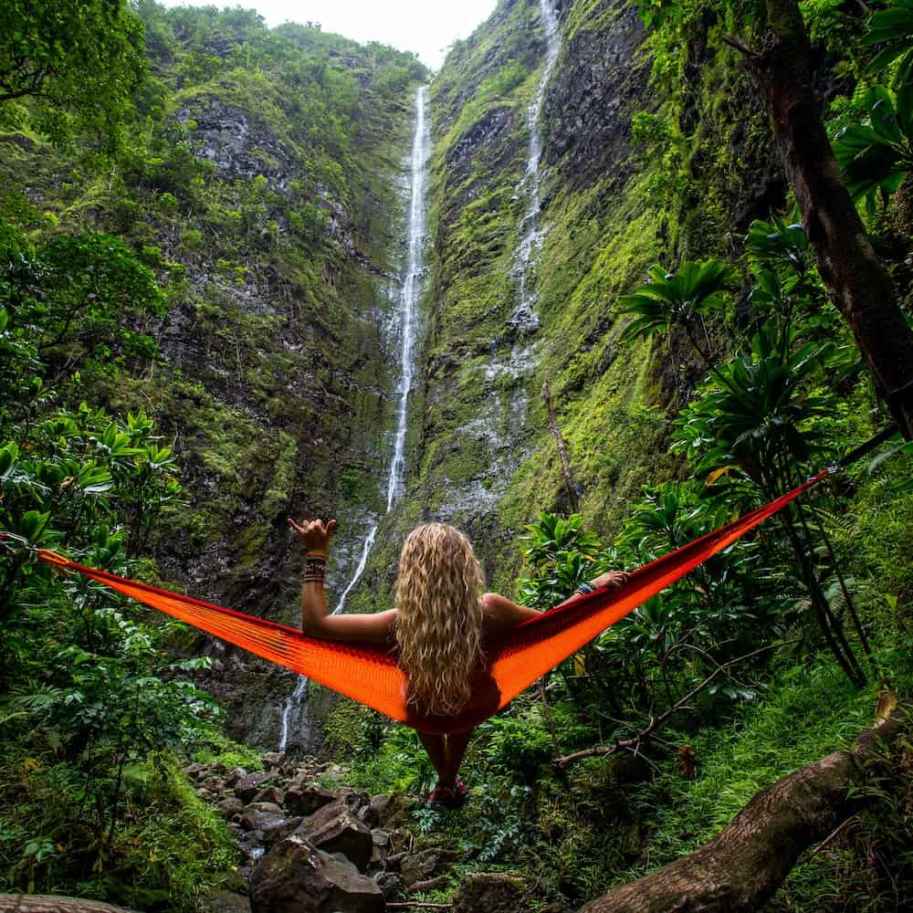 You’re Welcome in Hawaiian & 21 Common Phrases 3 Woman on a red hammock in front of a waterfall in Hawaii