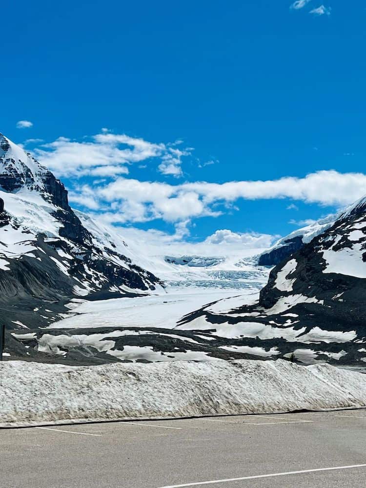 19 Best Stops on the Jasper to Lake Louise Drive 4 Athabasca Glacier with blue and white ice on black rocks.