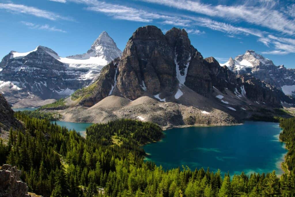 11 Epic Sites for Backcountry Camping in Canada (2024) 2 Mount Assiniboine Provincial Park in BC with the snow capped Rocky Mountains in the background. The pine tree forest is an excellent place for backcountry camping in Ontario.