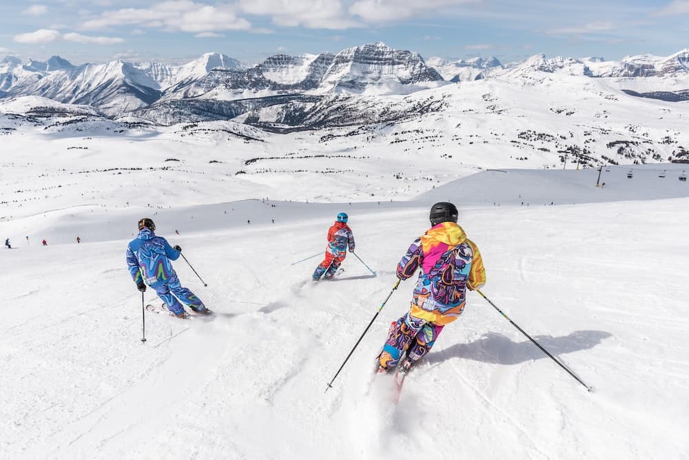 When is winter in New Zealand? (& Should You Visit?) 5 Three people in bright snowsuits skiing