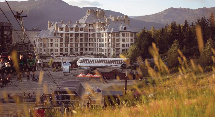 11 Best Resorts in Whistler (2024 Guide) 3 Pan Pacific Whistler Mountainside with a view of the gondola in the foreground and the white sandstone of the resort in the background with the mountains behind.