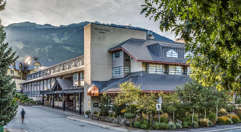 11 Best Resorts in Whistler (2024 Guide) 9 The Listel Hotel Whistler against green trees and the large mountains.