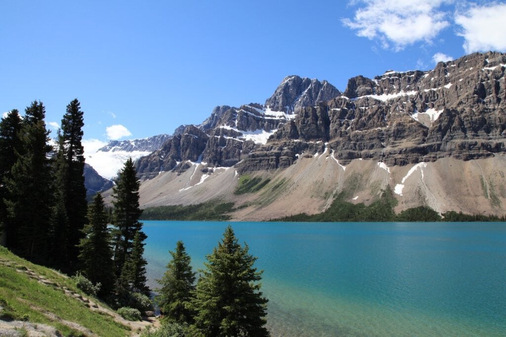 Banff National Park Itinerary: 1, 3, and 5 Day Guides 19 The blue Bow Lake, a great stop during your Banff itinerary, is surrounded by trees, and rock mountains.