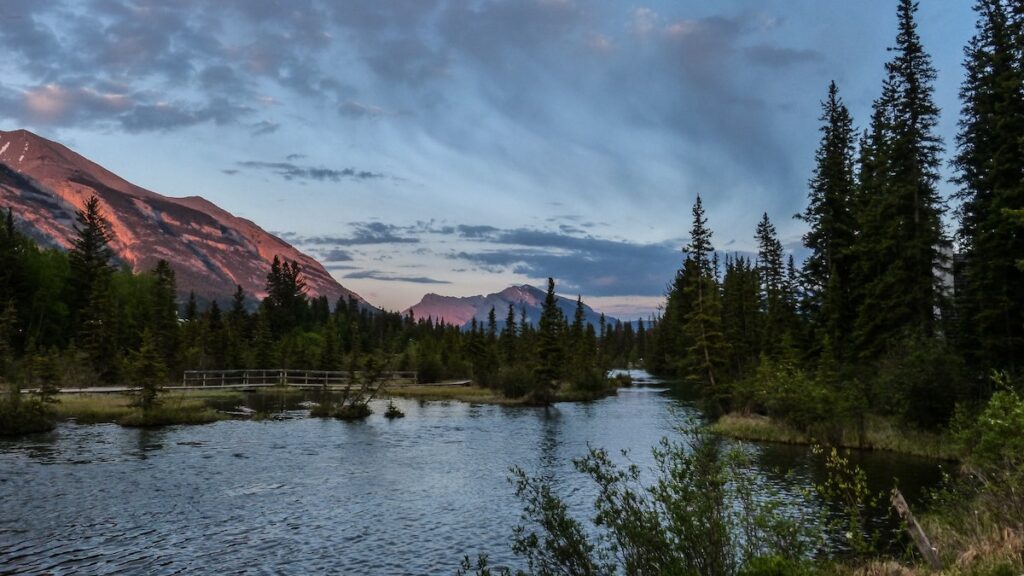 Banff National Park Itinerary: 1, 3, and 5 Day Guides 15 A view from Canmore that is abundant with trees and a calm lake.