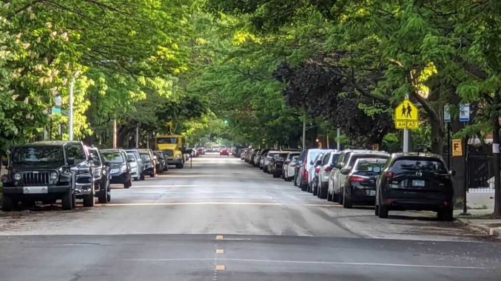 23 Pros and Cons of Living in Chicago in 2024 5 A road in Chicago full of parked cars on both sides - parking is one of the cons of living in Chicago.