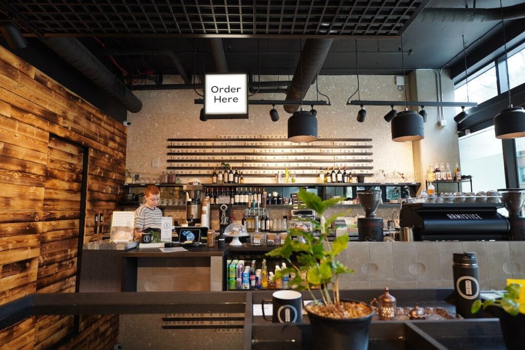 23 Pros and Cons of Living in Seattle in 2024 5 A coffee bar in Seattle with its barista organizing their station.