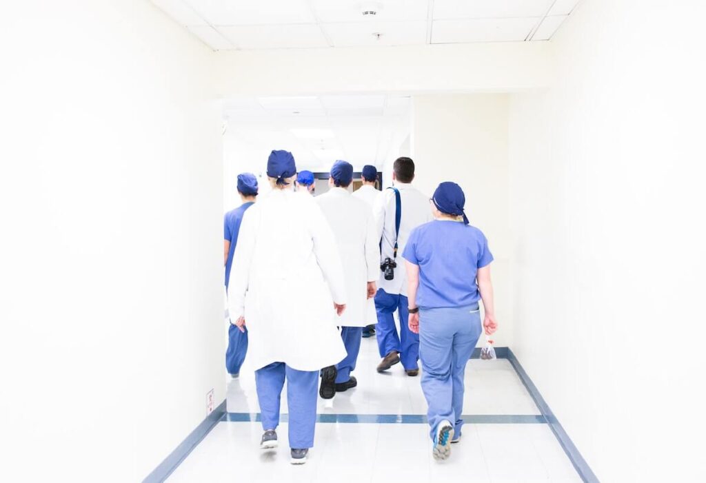 27 Pros and Cons of Living in Tennessee in 2024 8 Doctors and nurses in blue and white uniforms are walking in a hallway in the hospital in Tennessee.
