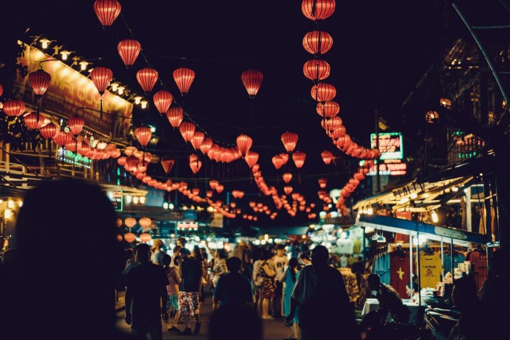 23 Pros and Cons of Living in Vietnam in 2024 3 A view from one of the night markets you can visit while living in Vietnam with red lanterns in at night.