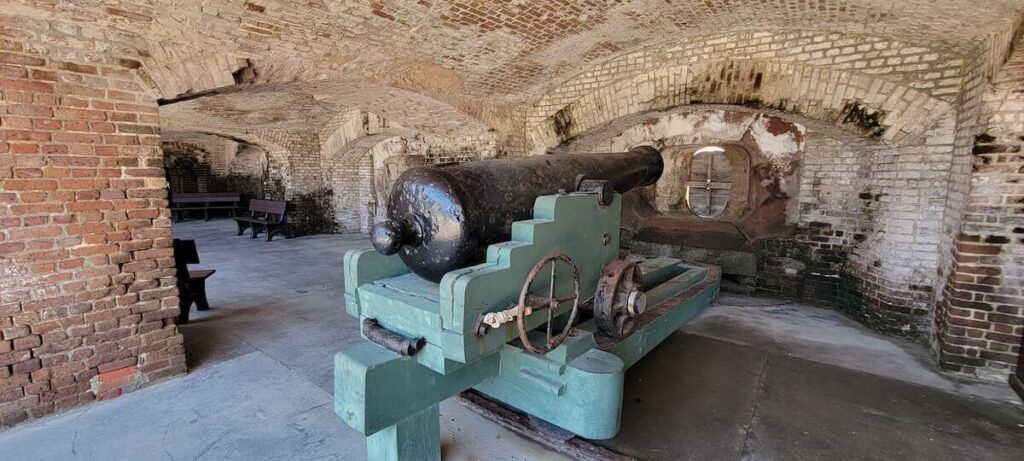 27 Pros and Cons of Living in South Carolina in 2024 2 A photo of an old cannon in a dungeon-like room in South Carolina.